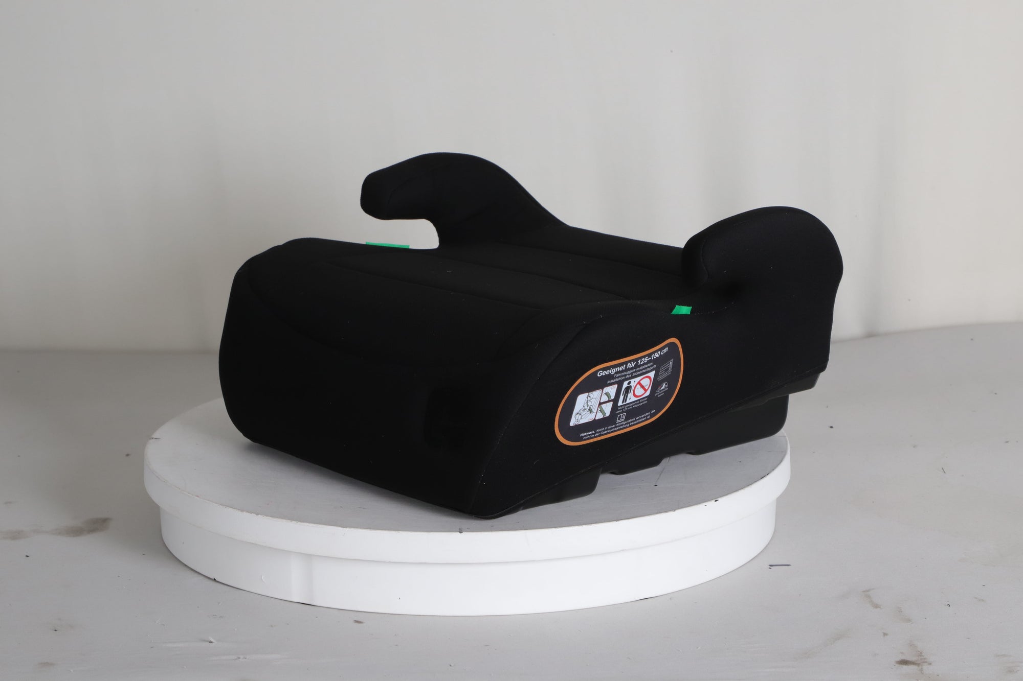 Mallie Booster Sitzerhoehung in Schwarz, 3/4 Ansicht mit Zulassungs-Hinweis 125 bis 150 cm